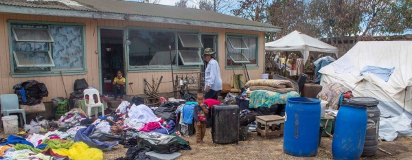 A family dry their belongings outside their home after it was damaged in the Hunga Tonga-Hunga Ha’apai underwater volcano eruption and tsunami.