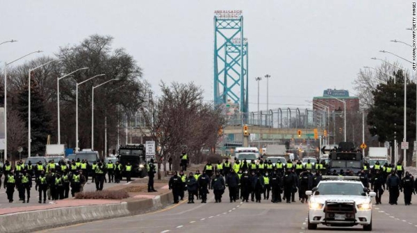 Police gather to clear protesters at the Ambassador Bridge in Windsor, Ontario, Sunday.