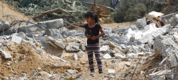 A girl stands near the rubble of a three-story home which was destroyed during heavy bombardment by Israeli forces in the Gaza Strip.