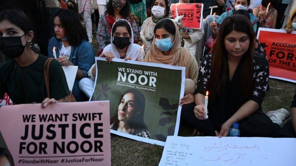 Women rights activists hold placards and candles during a protest rally in Islamabad against the brutal killing of Noor Mukadam.
