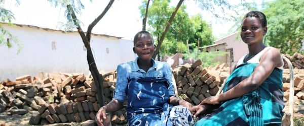 Yankho Alufandika (L) chats with her friend after receiving dignity kits. — courtesy UNFPA/ Joseph Scott