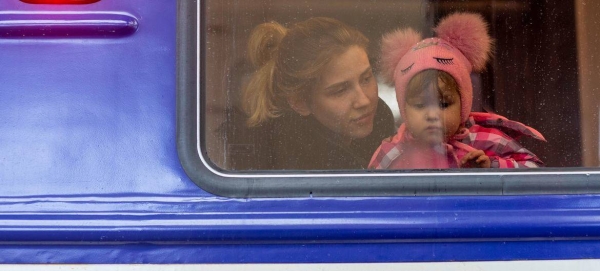 A girl looks out from a window as she waits inside an evacuation train to Przemysl in Poland, at Lviv train station, western Ukraine.