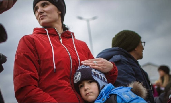 A Ukrainian mother comforts her seven-year-old son, while waiting for a means of transportation in Isaccea, Romania.