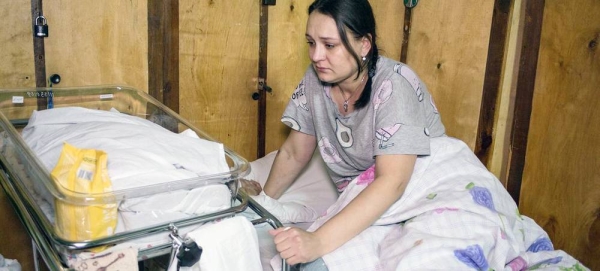 A new mother sits in a bed next to her baby in a makeshift maternity ward in a hospital in Kiev, Ukraine. — courtesy UNICEF/Oleksandr Ratushniak