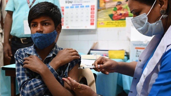A health worker inoculates a teen with a dose of a Covid-19 Corbevax vaccine in New Delhi on Wednesday.