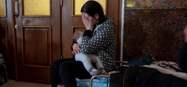 Ukrainians at Lviv train station prepare to leave their country.
