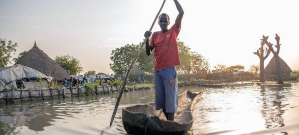 An ex-farmer displaced by flooding, paddles his canoe from his home in Old Fangak, South Sudan. — courtesy UNHCR/Samuel Otien