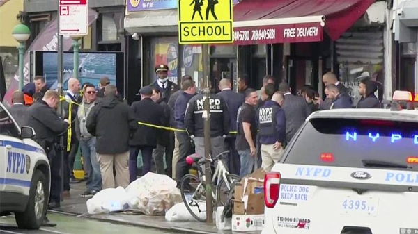 This image provided by WABC shows law enforcement gathering at the scene of a shooting in the Brooklyn borough of New York on Tuesday.