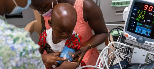 A two-year-old girl with cancer gets her vitals taken by a nurse at a hospital in Ghana.
