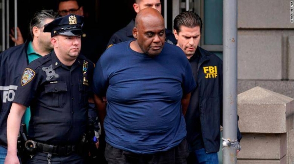 New York City Police and law enforcement officials lead subway shooting suspect Frank James, 62, center, away from a police station in New York, Wednesday.