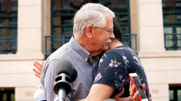 

Carl Mueller, father of late US aid worker Kayla Mueller, hugs her friend after a jury convicted El Shafee Elsheikh on terrorism charges.


