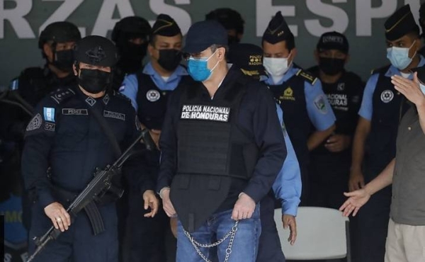 The former president of Honduras is being led away from his home in handcuffs.