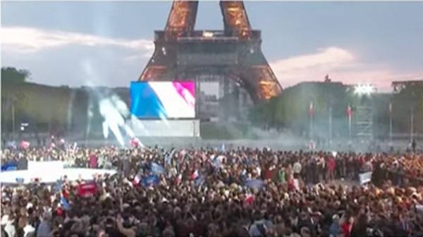 A goodly crowd near the Eiffel Tower savor the news that French President Emmanuel Macron was re-elected on Sunday with 58% of the vote compared to 42% for far-right candidate Marine Le Pen.