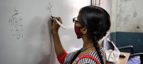 A 13-year-old girl solves a math problem at a school in Gujarat, India.