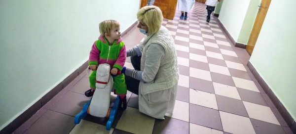 A Ukrainian girl comforts her six-year-old brother as they prepare to leave a UNICEF-supported centre in Romania for their next destination. — courtesy UNICEF/Alex Nicodim
