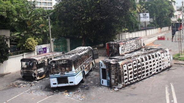 Burned buses near the official residence of Sri Lanka's outgoing prime minister Mahinda Rajapaksa in Colombo, a day after they were torched by protesters on May 10.