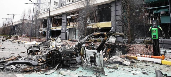 A destroyed car and damaged buildings in Bucha, Ukraine. — courtesy UNDP/Yevhenii Zavhorodnii