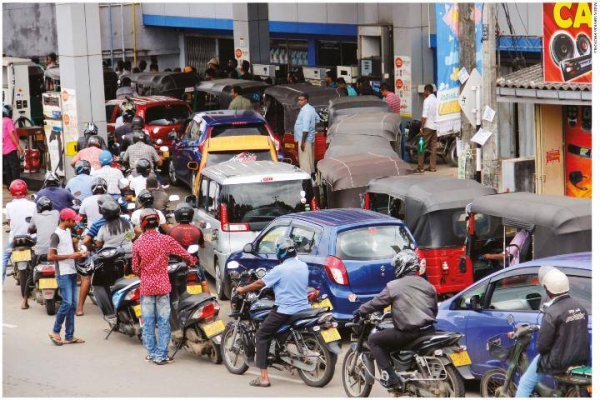 Vehicles queue at a petrol station in Colombo.

