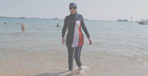 A Muslim woman, wearing a full-body burkini swimsuit, walks on a beach in Cannes.