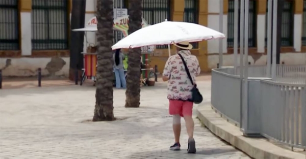 A person uses the protection of the umbrella to ward of the heat after temperatures soared this weekend, reaching up to 15 degrees above average for the season, in Spain.
