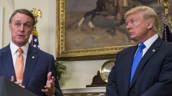 David Perdue and Donald Trump photographed together at the White House in 2017.
