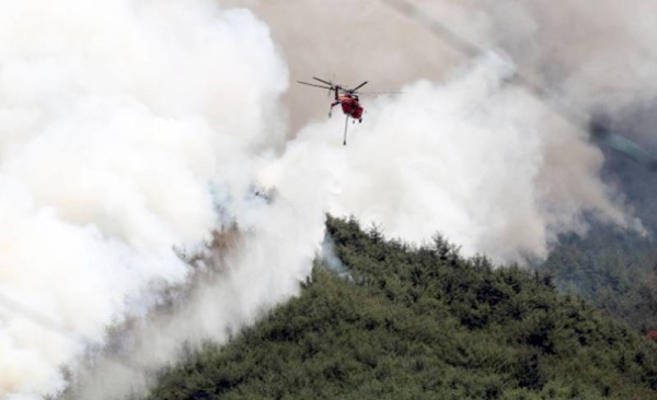 Firefighter put out the flames with a helicopter in Miryang-si, Gyeongsangnam-do on Tuesday. — courtesy Yonhap