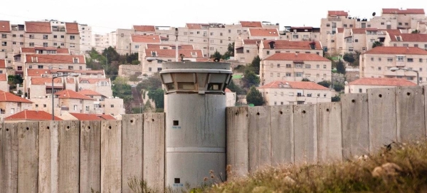 The Separation Wall in the occupied Palestinian Territory and behind it an Israeli settlements.