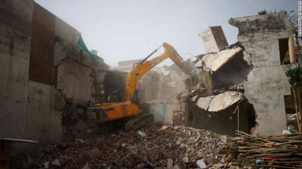 A bulldozer demolishes the house of a Muslim figure in Uttar Pradesh state.