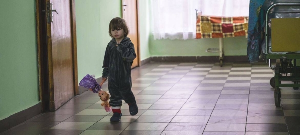 A small child, displaced from an orphanage in the Kharkiv region, walks in the hall of a shelter located in a sanatorium in Vorokhta, western Ukraine.