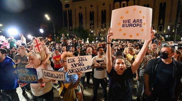 Waving European and Georgian flags, an estimated 60,000 demonstrators gathered in front of the Georgian parliament on Monday