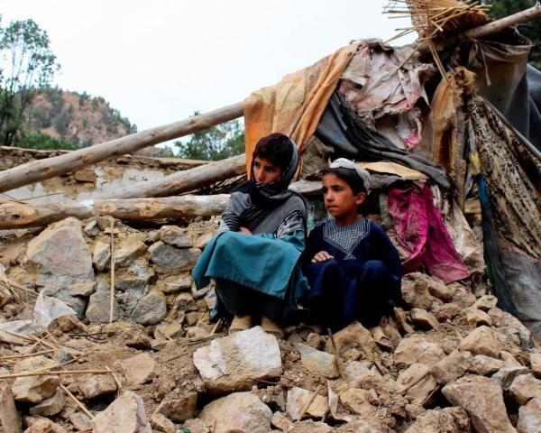 Children sit near their home that was destroyed in the earthquake in Spera district, southwest of Khost, on Wednesday.