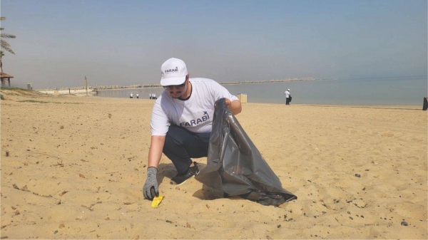 Farabi Petrochemicals employees pose after beach clean-up at the Dareen Beach in Jubail Industrial City.