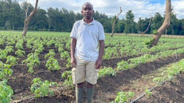 Tomato farmer Lossim Lazzaro standing in front of crops.