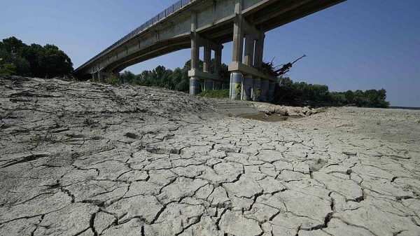Dry cracked land is visible under a bridge in Boretto on the bed of the Po river.
