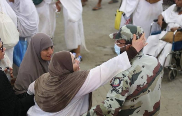 Security personnel serving pilgrims with smiling faces and caring hands