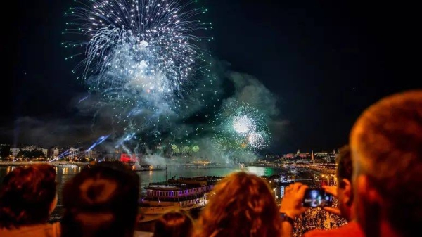 People look at fireworks over the Danube river and the parliament during celebrations to mark Hungary's national day in Budapest on August 20.
