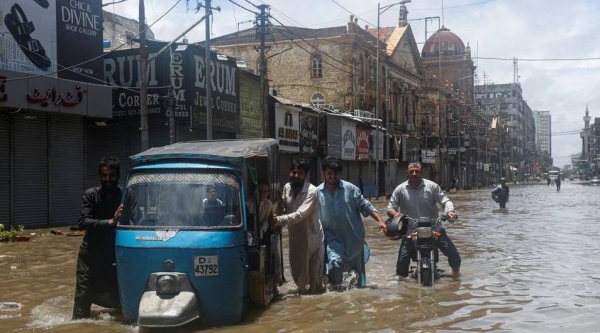 Residents wade through a flooded street in Karachi.