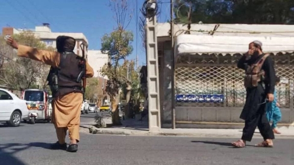 Taliban fighters block a road after the blast at Herat's Gazargah mosque