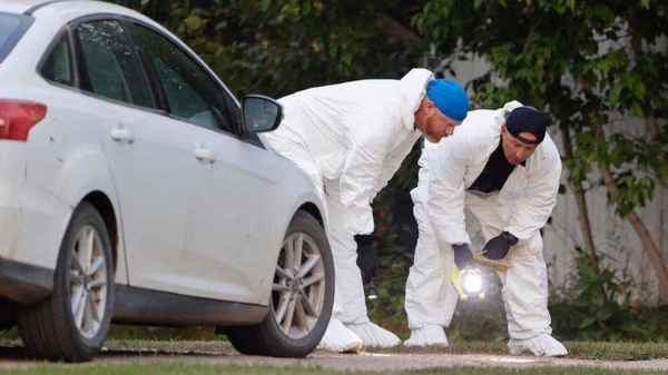 Forensic investigators at one of the crime scenes. 