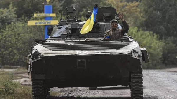 A soldier waves from a Ukrainian tank as it travels towards to the frontline near Kharkiv