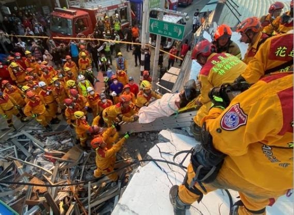 Firefighters rescue a person at the site where a building collapsed following a 6.8-magnitude earthquake, in Yuli, Hualien county, Taiwan.