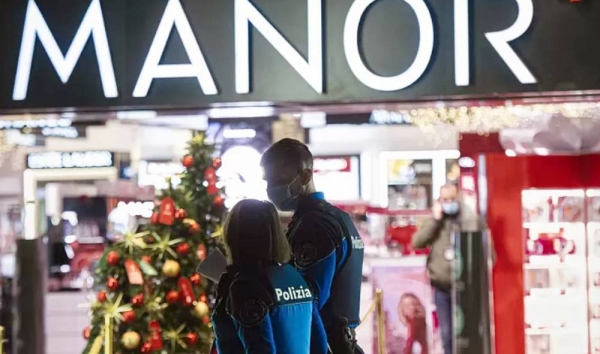 Police walk near the area where the stabbing occurred in a department store in Lugano. — courtesy photo