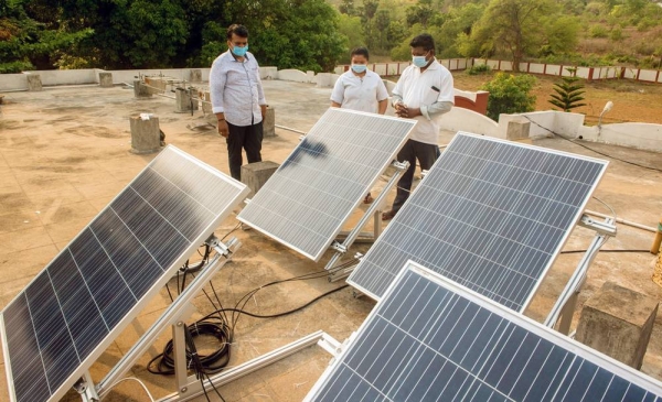 A woman installs a solar panel on a roof in Bhutan. —courtesy ADB