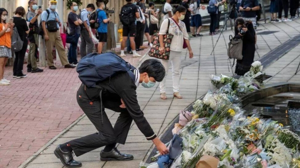 A mourner placing a flower bouquet outside the British Consulate General in Hong Kong.