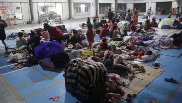 Evacuees rest inside a gymnasium turned into a temporary evacuation center in Manila.