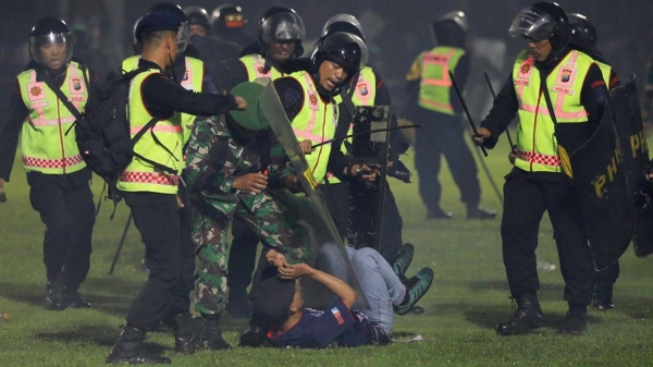 Police officers detain a fan