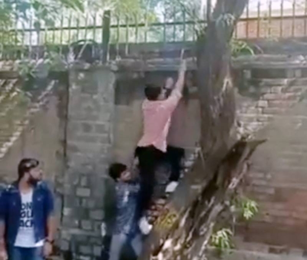 Indian police have opened an investigation after a viral video showed some men scaling the walls of a women's college in capital city Delhi.