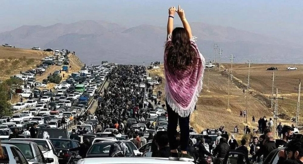 A young woman without a hijab stands on a car as a huge crowd walks towards the Aichi cemetery in Saqqez, Iran, to visit Mahsa Amini's grave on Wednesday. — courtesy Twitter