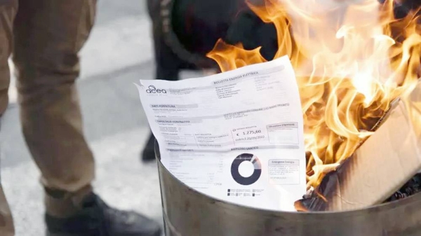 A utility bill burns during a protest by shopkeepers against the costs of living, in Turin, Italy, Tuesday. — courtesy Matteo Secci/LaPresse