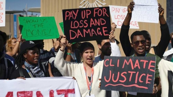 Protestors hold placards calling for climate justice.